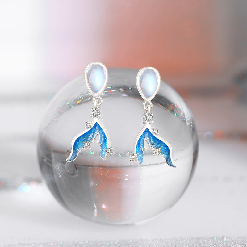 A pair of elegant 925 sterling silver drop earrings featuring a blue mermaid tail design with shimmering moonstone accents.
