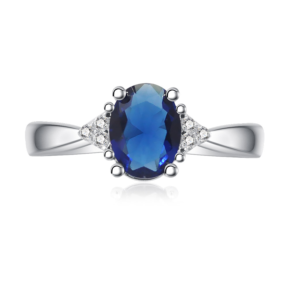 Oval Sapphire and Zirconia Ring featuring a large oval blue sapphire centerpiece flanked by sparkling zirconia stones.
