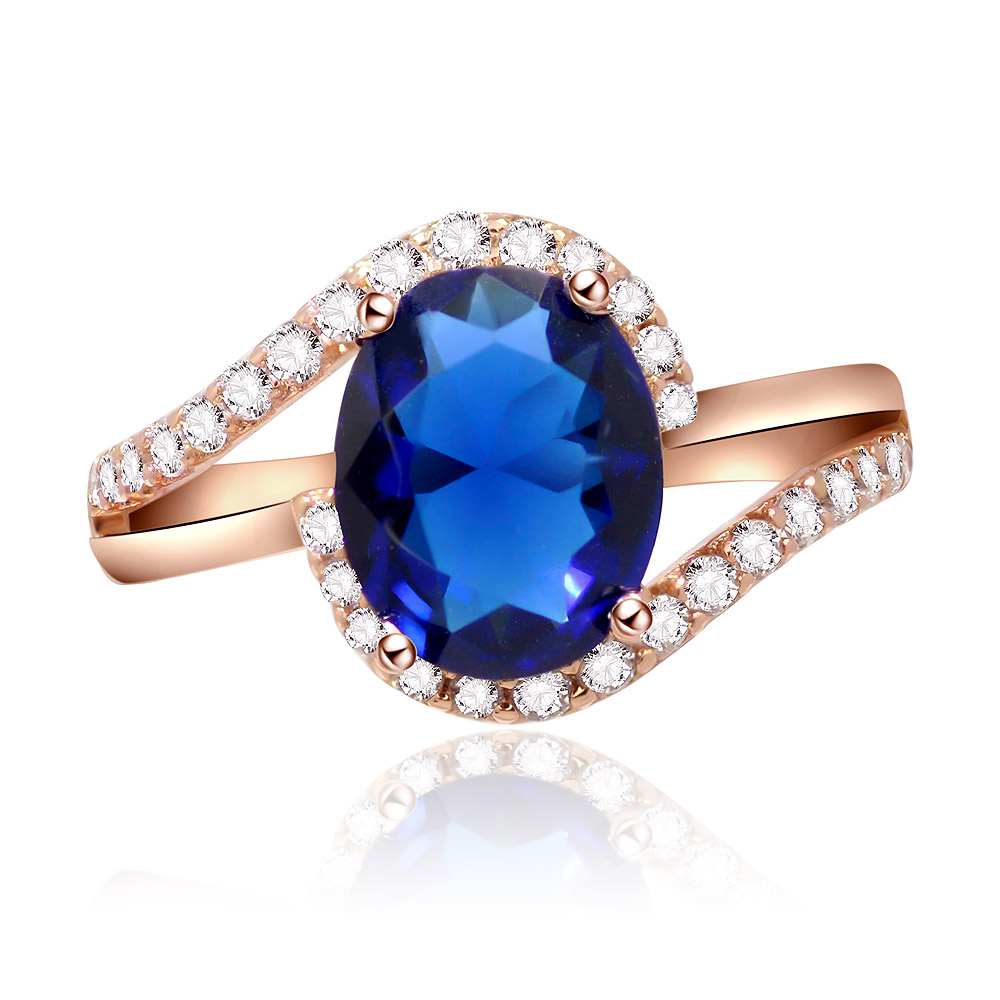 Front view of the Oval Sapphire Zirconia Swirl Ring, showcasing the large oval blue sapphire centerpiece surrounded by sparkling diamonds on a rose gold band.