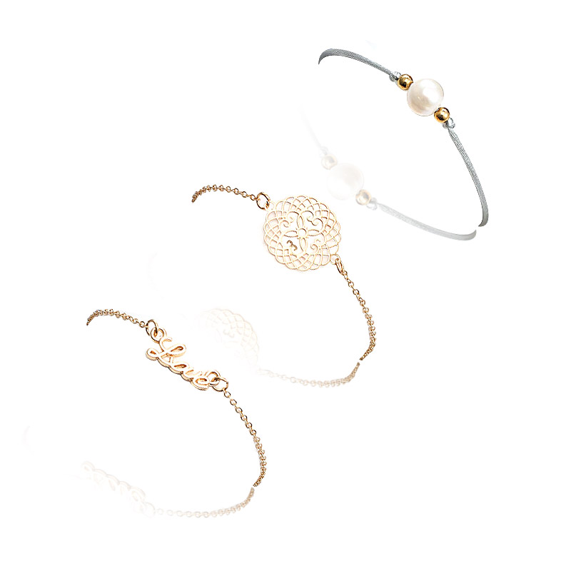 A collection of three Love Pearl Stacking Bracelets, featuring gold-plated brass, pearls, and unique charms, displayed on a white background.