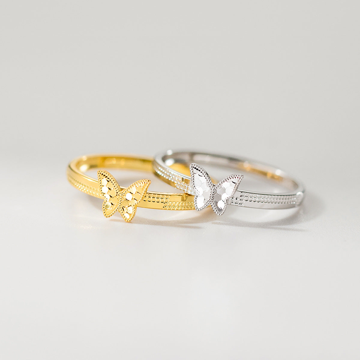 A wholesale set of minimalist 925 sterling silver butterfly rings, shown in both elegant gold and classic silver finishes, perfect for everyday fashion jewelry.
