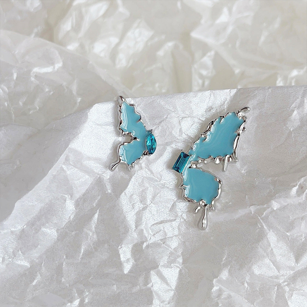 A pair of silver-plated, butterfly-shaped stud earrings with delicate light blue enamel and sparkling zircon stone accents.