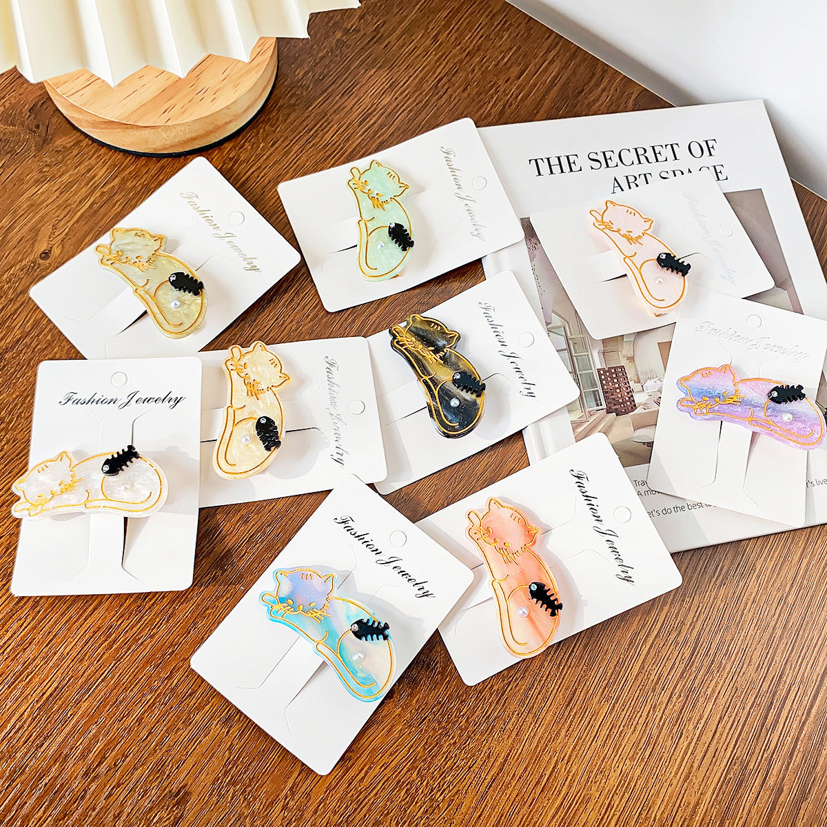 A collection of colorful cat-shaped acetate hair clips with pearl details, displayed on 'Fashion Jewelry' cards, showcasing the variety available in the 5-piece set.