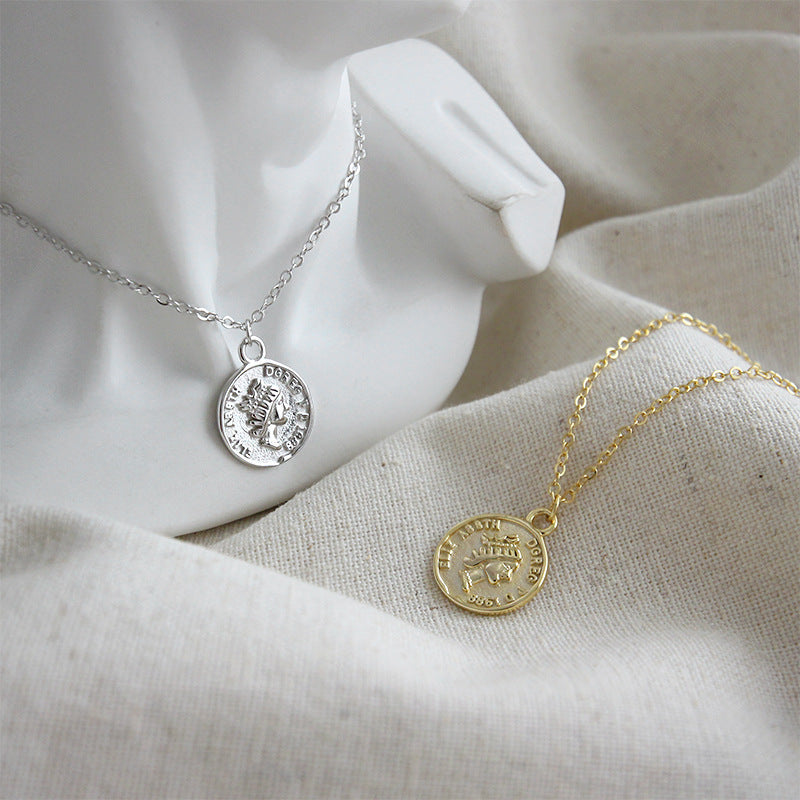 A pair of vintage coin portrait pendant necklaces, one in 18K gold and one in platinum-plated 925 sterling silver, displayed side-by-side.