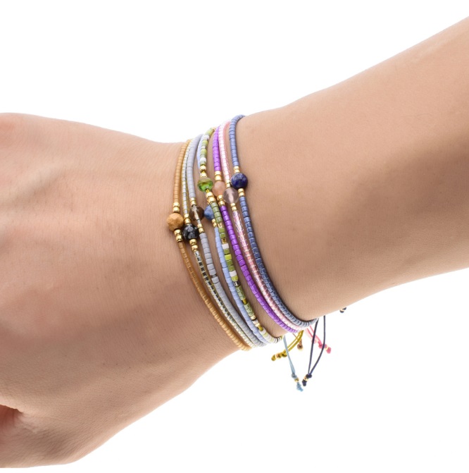 A woman's wrist adorned with multiple colorful faceted bead strand bracelets, showcasing the vibrant style of the JRH-041 design from the Spring/Summer collection.