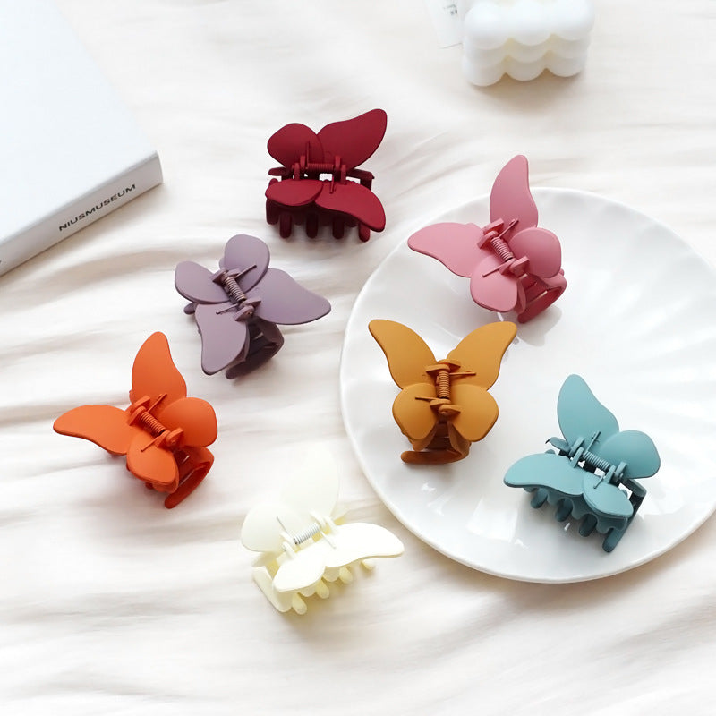 A vibrant collection of butterfly jaw clips in various matte and translucent colors, neatly arranged to showcase the full set.