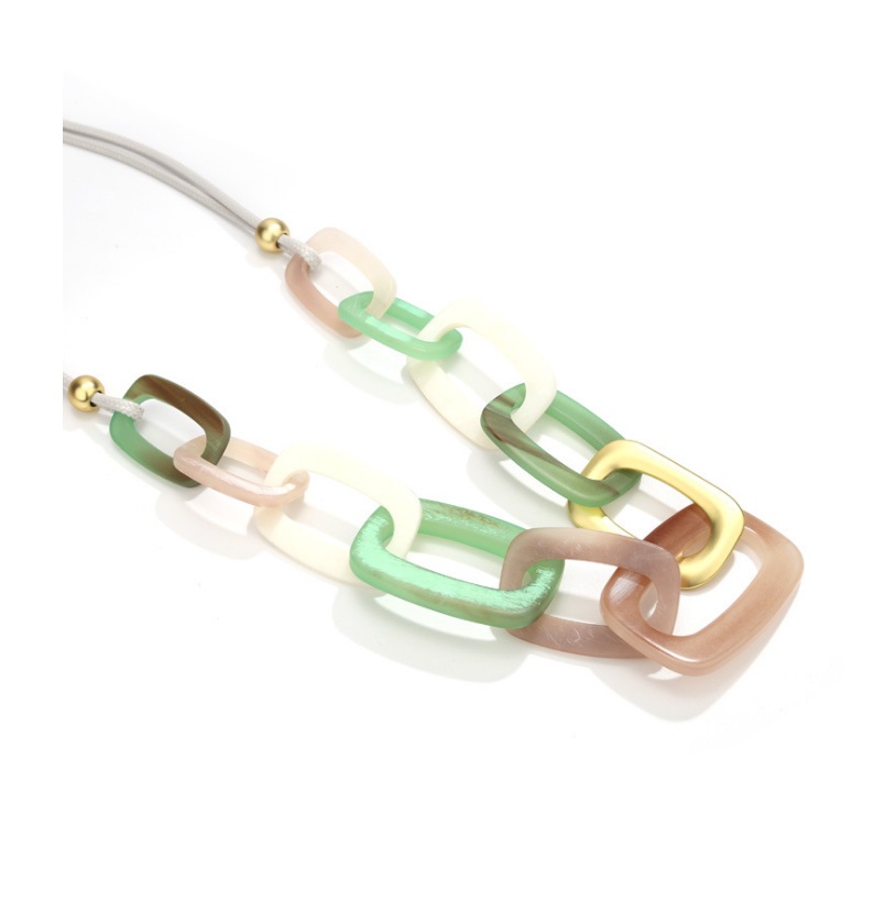 Close-up of the Hollow Oval Resin Charm Necklace, featuring vibrant green, pink, and white resin links interconnected with gold-plated chains.