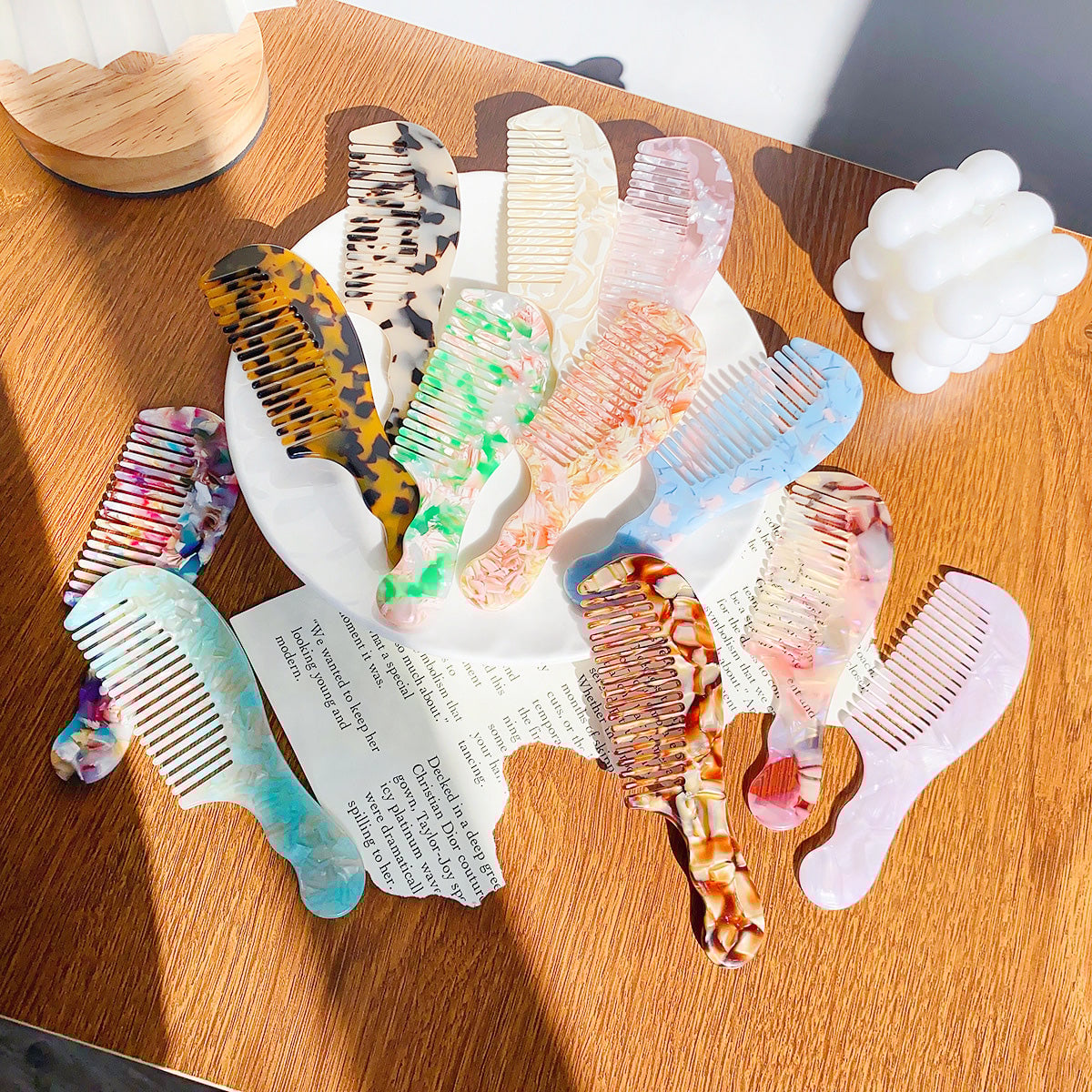 A vibrant collection of portable acetate hair combs in various marbled colors and patterns, displayed on a white surface.