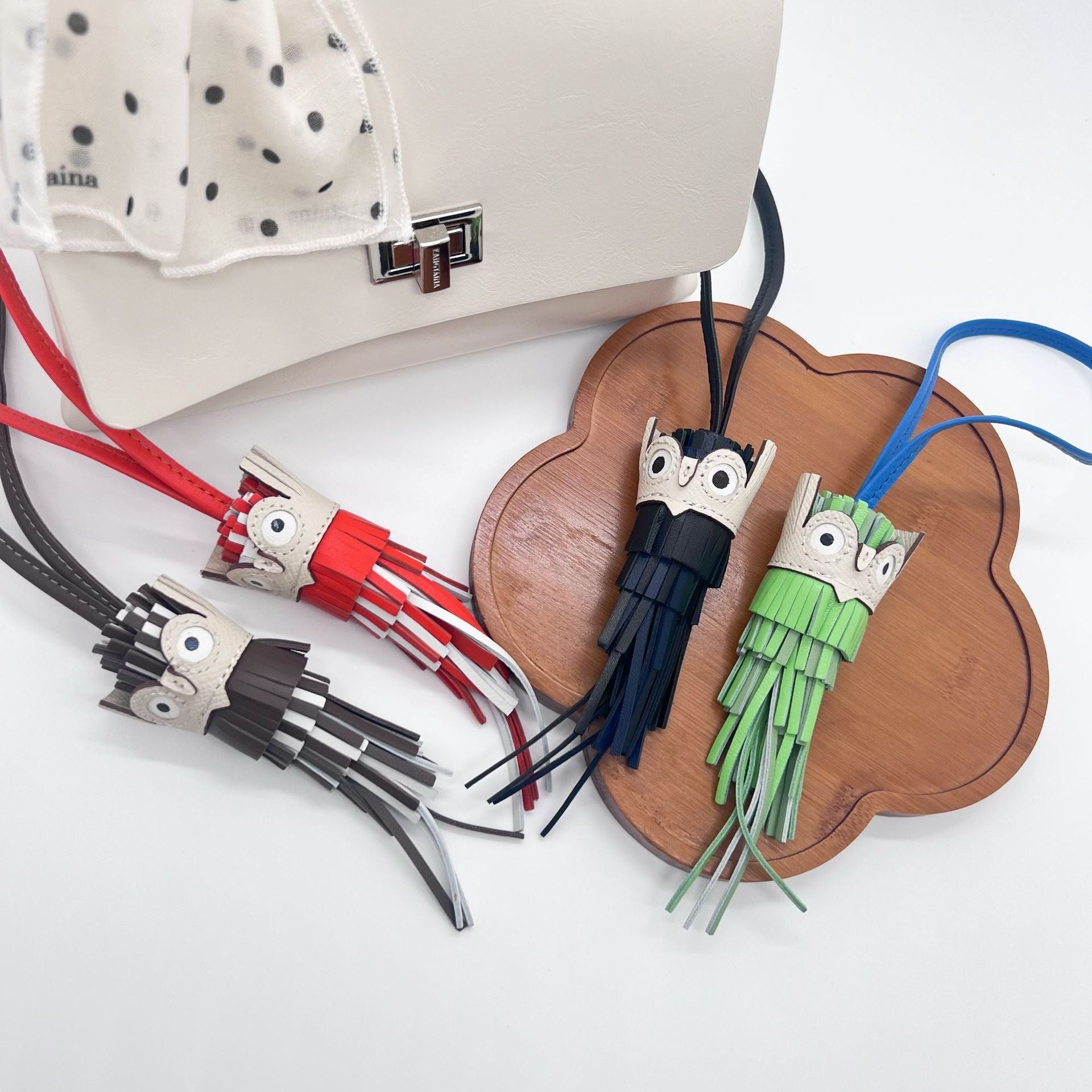 A vibrant collection of handmade leather owl keychains with tassels, available in multiple colors for wholesale.