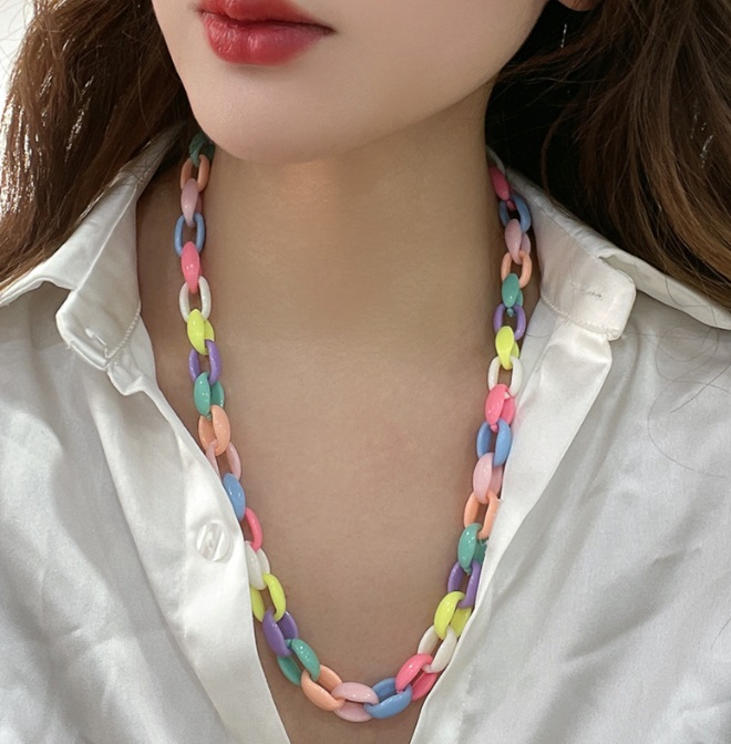 A close-up of a colorful pastel acrylic chain necklace, model JRN-061, offered for wholesale by JR Fashion Accessories. The necklace features interlocking links in various soft colors.