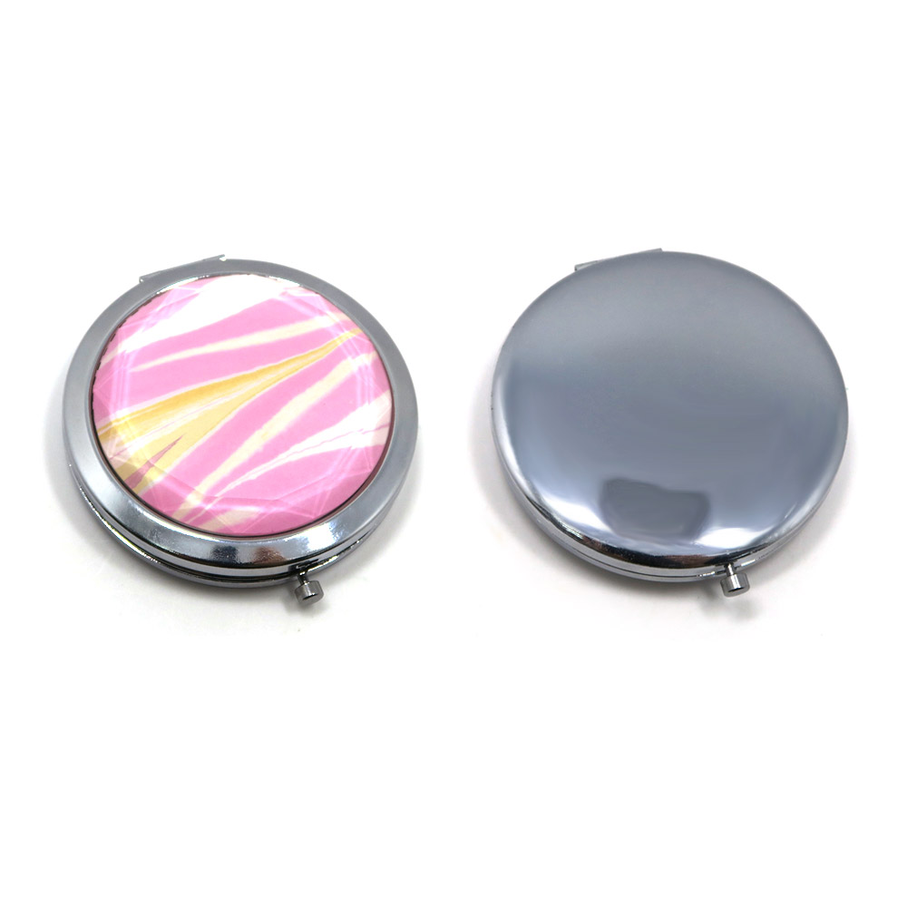A stylish round crystal pocket mirror with a pink and yellow design next to a classic silver compact mirror, showcasing customization options.