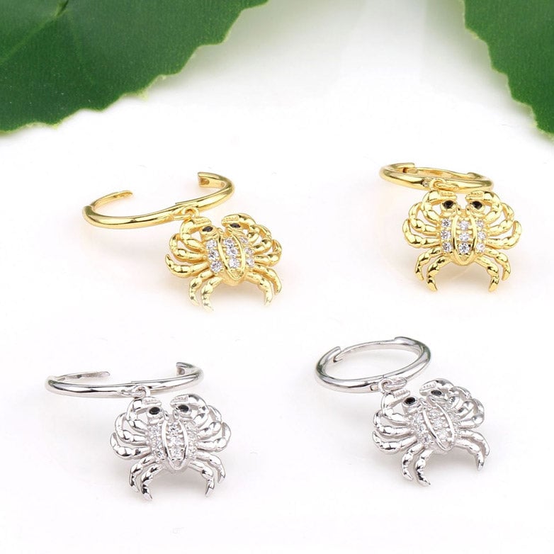 A detailed view of the 925 Sterling Silver Crab Huggie Hoop Earrings, showcasing both the gold and silver variants with sparkling gemstone details.