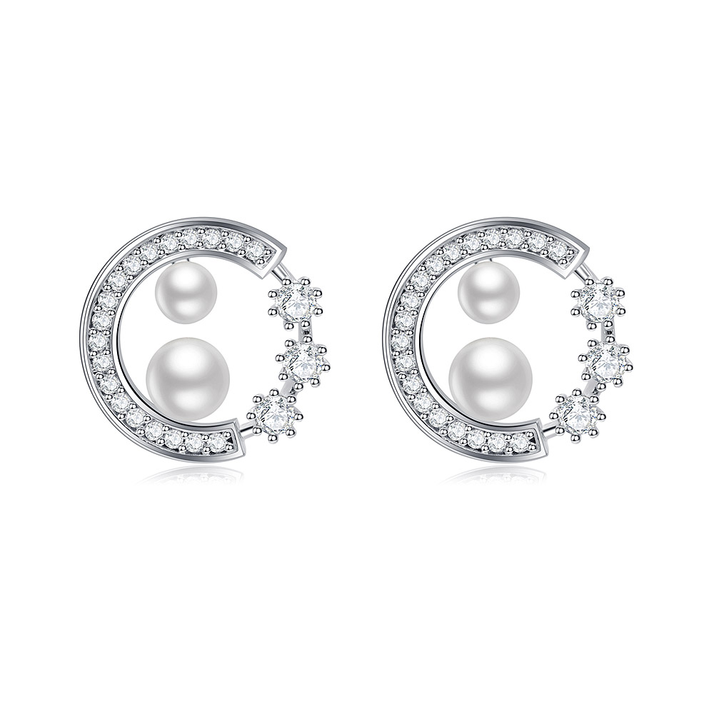 A pair of Enticing Pearl Stud earrings in a crescent moon design, featuring white cubic zirconia and pearls, displayed on a clean white background.