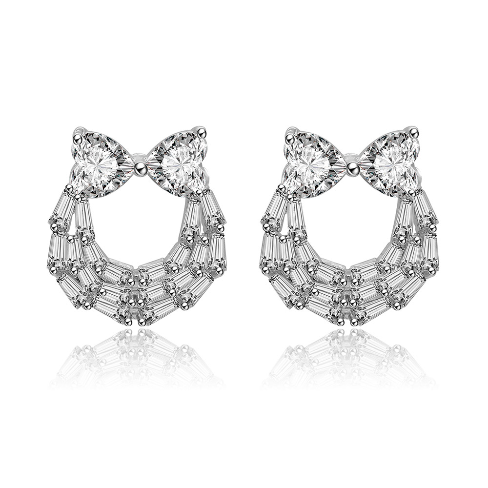 Front view of the Two Hearts And Baguette Earrings, showcasing the rhodium-plated brass setting with a heart-shaped cubic zirconia and a bow-like crystal frame.