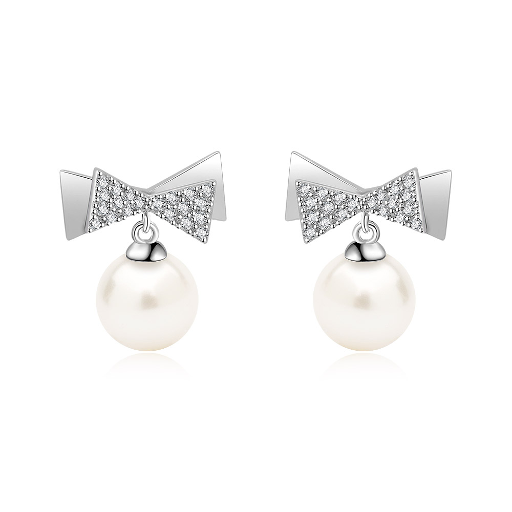 A close-up of the Bow 7mm Pearl Drop Earrings, showcasing the intricate diamond-encrusted bow design and the lustrous white freshwater pearl.