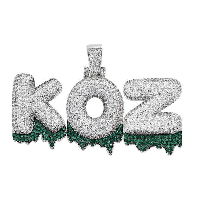 A custom iced out name pendant spelling 'KOZ', lavishly set with white and green cubic zirconia stones, showcasing personalized hip-hop jewelry craftsmanship.