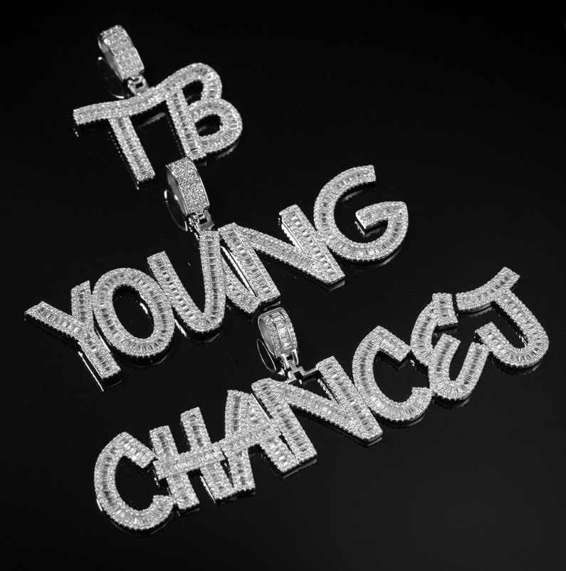 A custom iced out pendant featuring the words 'TB YOUNG CHANCE' fully encrusted with sparkling diamonds, showcasing JR Fashion's hip hop jewelry craftsmanship.