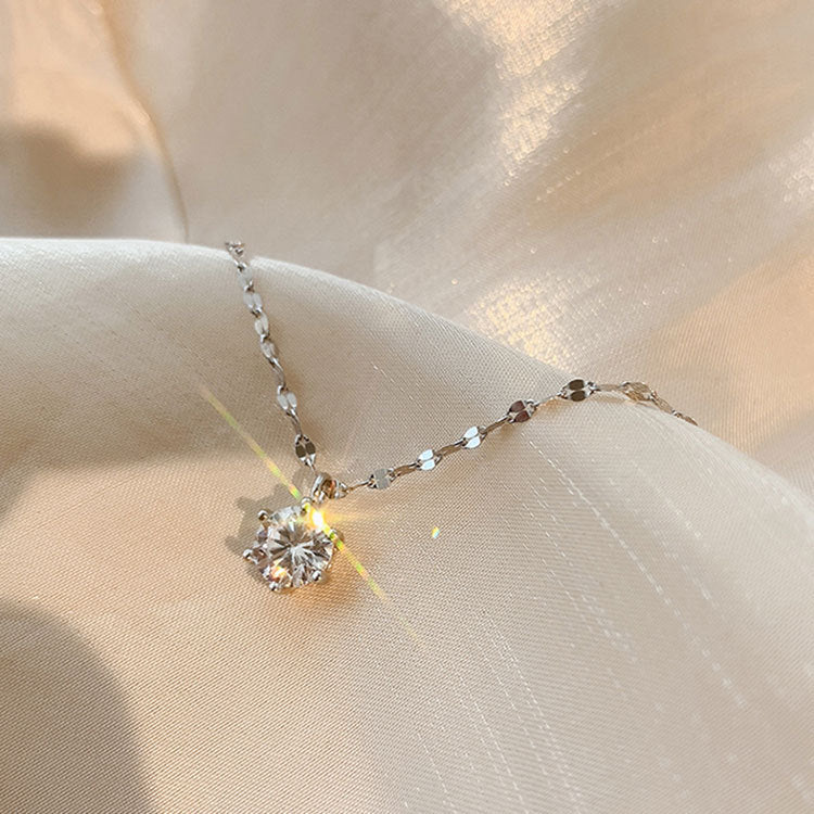 Close-up of a 925 sterling silver necklace with a classic six-claw zircon pendant on a neutral background.