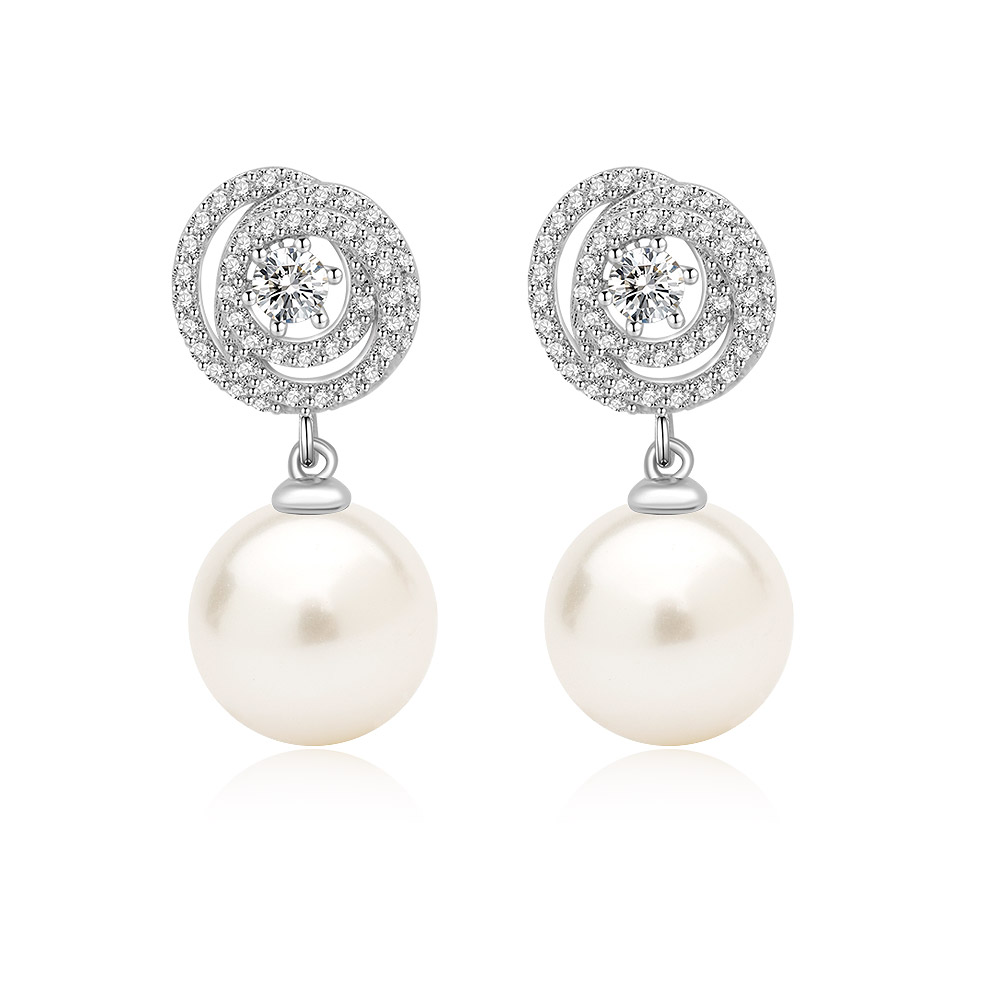 A close-up of the Swirl Round 10mm Pearl Drop Earrings, showcasing the intricate rhodium-plated swirl design studded with sparkling cubic zirconia, leading down to a lustrous 10mm white shell pearl.