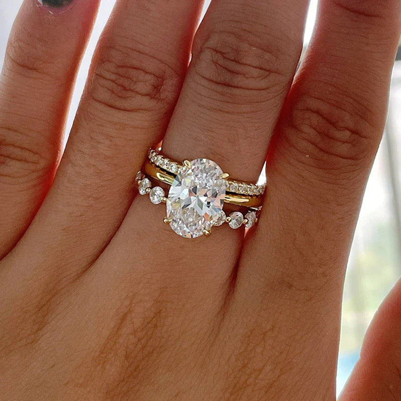 A woman's hand wearing the Taylor Swift inspired oval cut CZ engagement ring and matching wedding band, showcasing the elegant 925 sterling silver design.