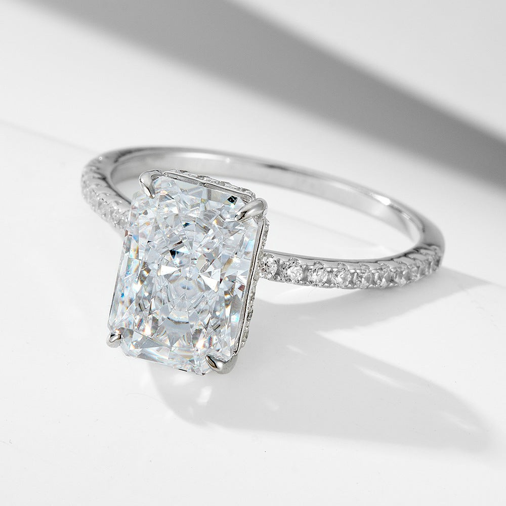 Close-up of a 925 sterling silver radiant-cut CZ engagement ring, showcasing the large rectangular center stone and sparkling pavé band.