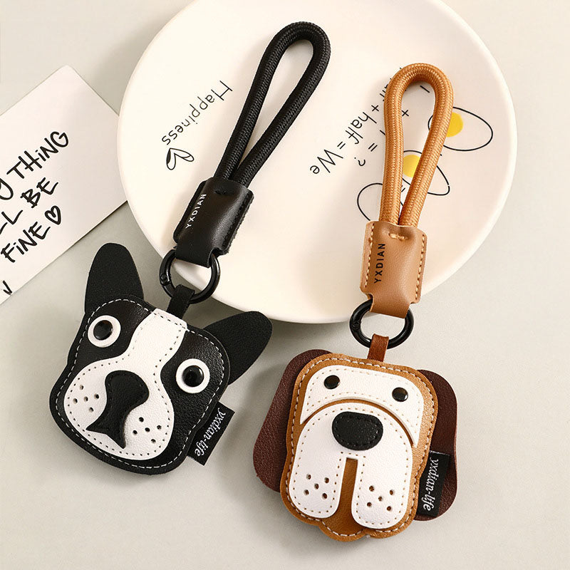A pair of creative cartoon puppy keychains, one black Bulldog and one brown Beagle, made from PU leather, displayed together.