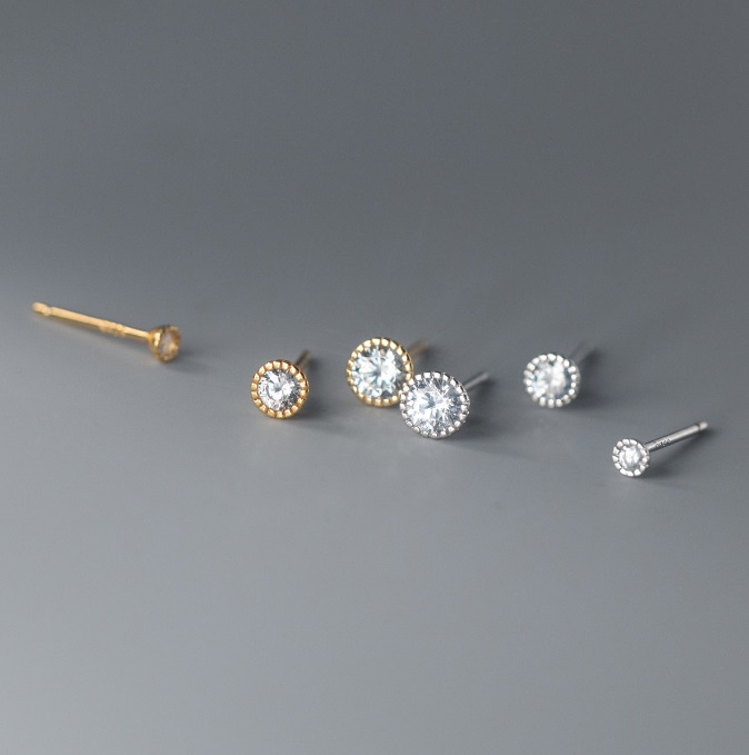 A pair of 925 sterling silver halo stud earrings with clear cubic zirconia gemstones, shown in both silver and gold plating options.