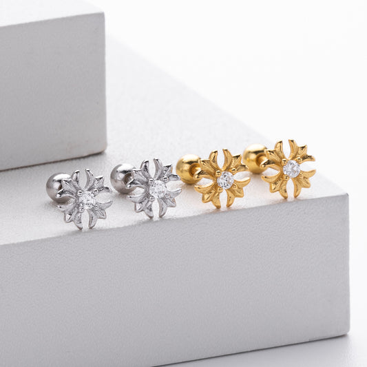 A collection of wholesale 925 sterling silver earrings, featuring four flower-shaped studs in silver and gold finishes with central cubic zirconia stones.