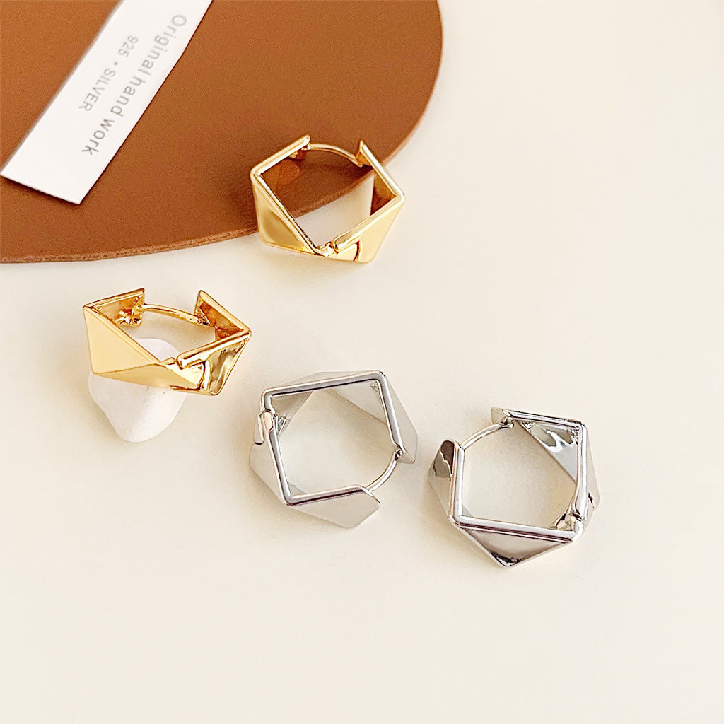 A product shot of geometrical design hoop earrings, showcasing both the gold and silver plated brass options on a clean white background.
