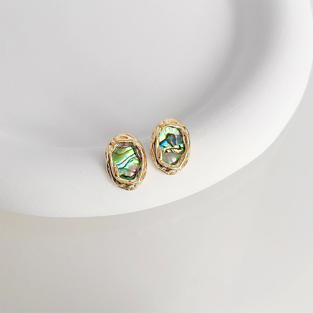 A set of five pairs of 14k gold-plated oval stud earrings featuring vibrant abalone shell inlays, displayed on a white surface.