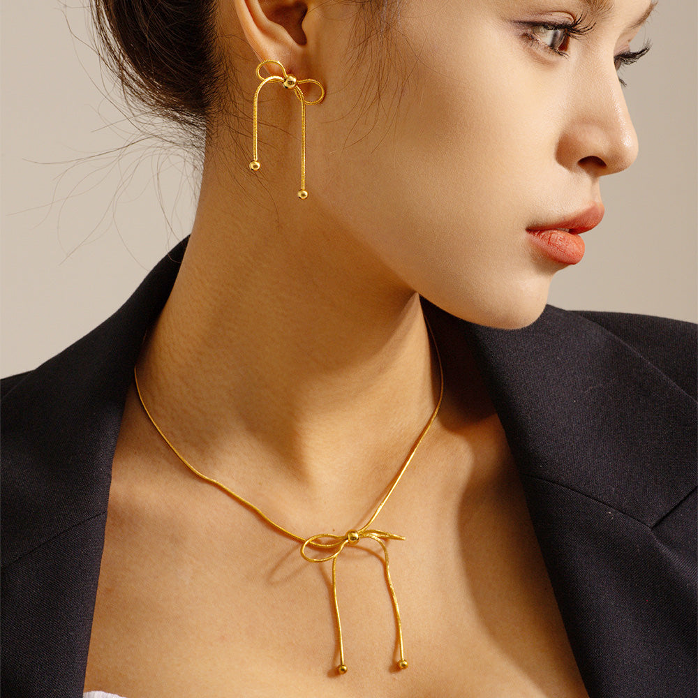 A model showcasing the elegant Stainless Steel Gold Knot Bow Stud Earrings, highlighting their chic design and comfortable fit.