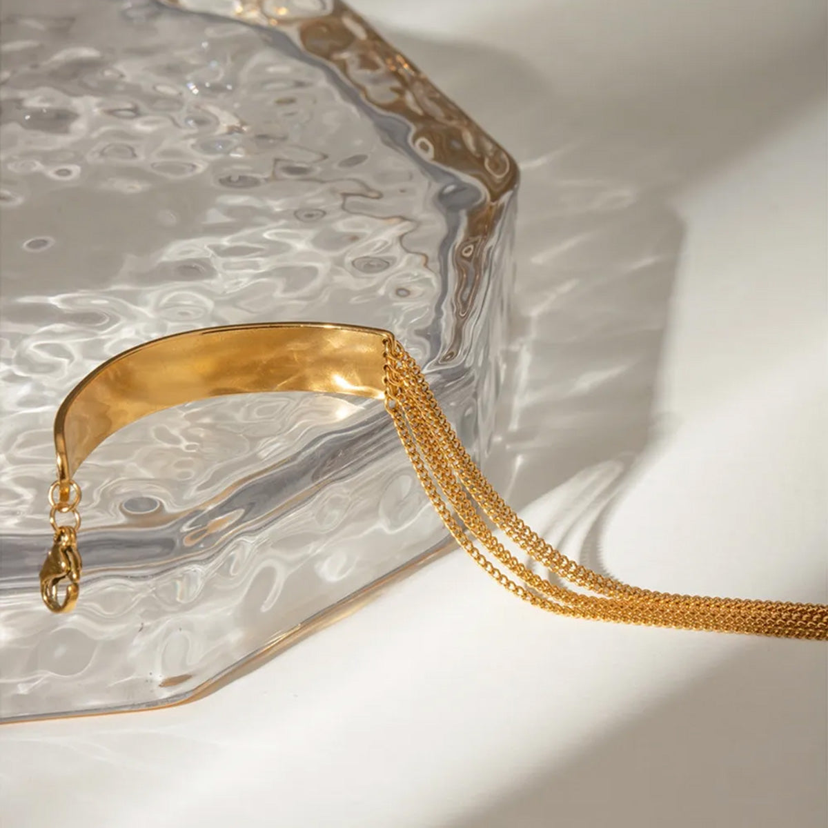 A stylish set of five gold stainless steel chain bracelets for women, featuring layered and Cuban link designs, displayed on a clean background.