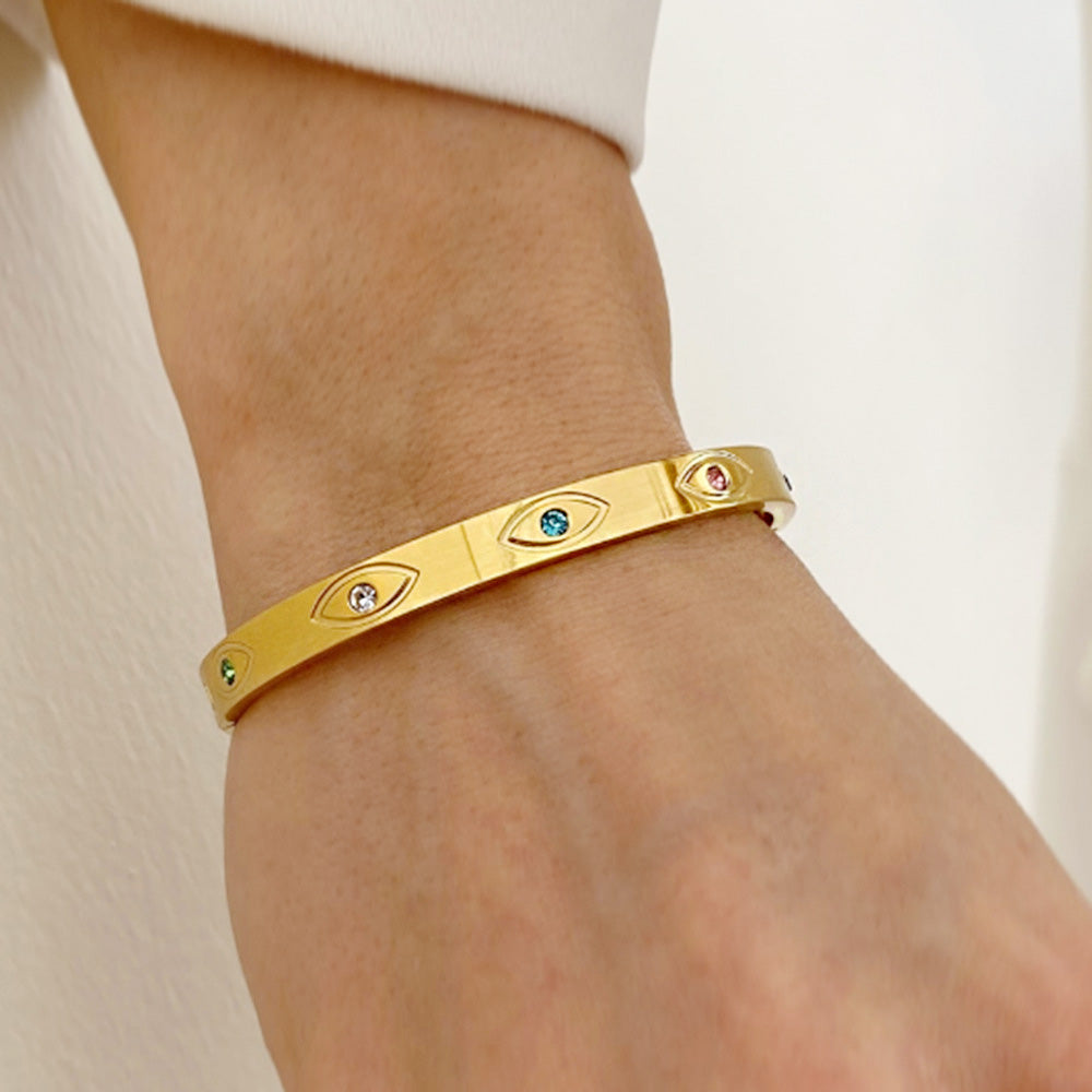 A model wearing the stainless steel gold color zircon evil eye bangle set, showcasing its elegant design on the wrist.