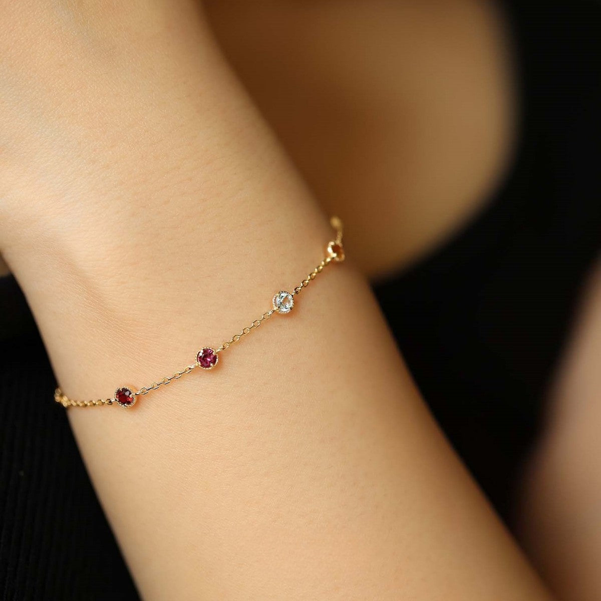 A close-up of the 925 Sterling Silver Bracelet with 18K Gold Plating, showcasing the vibrant, colorful cubic zirconia gemstones on a delicate chain.