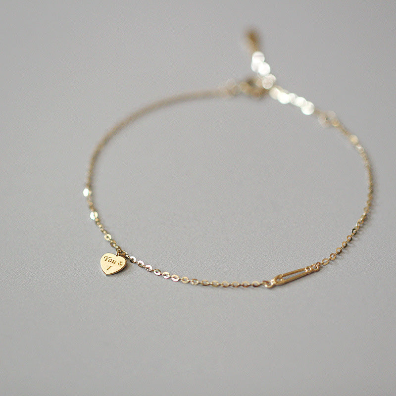 Close-up of the 925 Sterling Silver 'You & I' heart charm bracelet, showcasing the detailed engraving on the gold-plated heart charm.