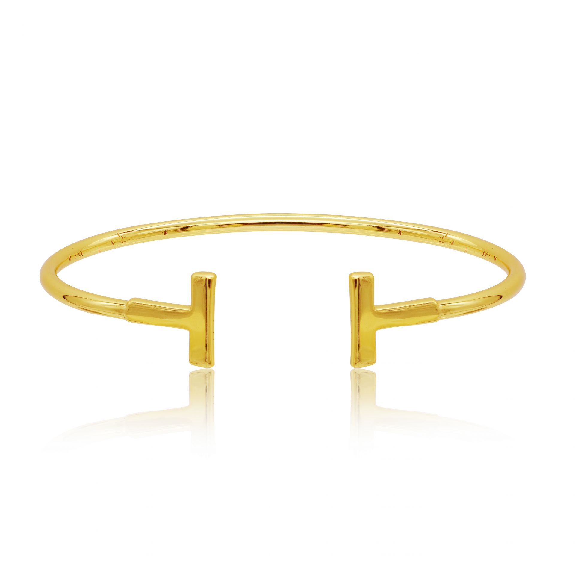 A close-up of the Modern Polished Bar Bangle in gold, showcasing its sleek design and distinctive T-shaped ends.