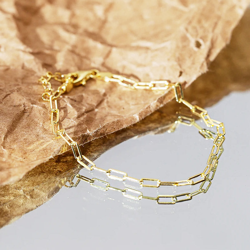 A close-up product shot of a 925 sterling silver paper clip chain bracelet with a gold finish, displayed on a neutral background.