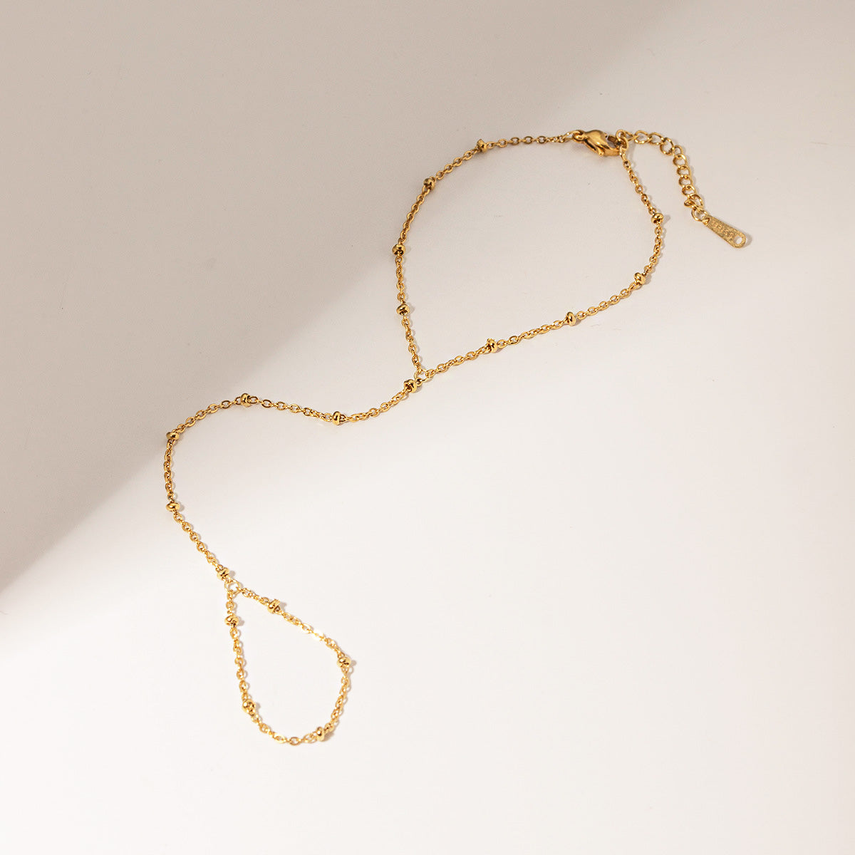 Detailed product view of the gold-plated stainless steel bead chain bracelet, highlighting the clasp and fine craftsmanship.