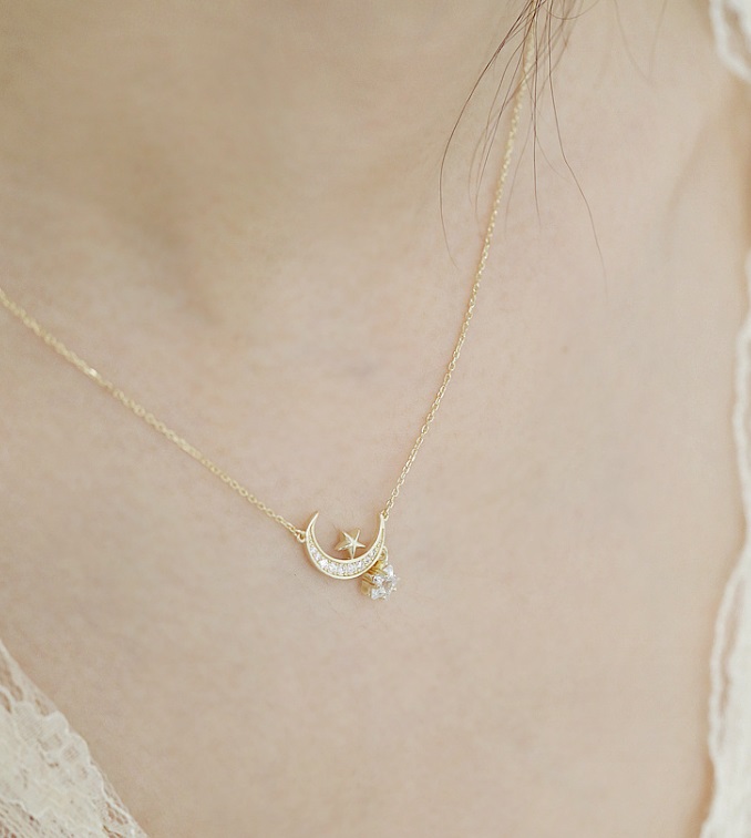 A close-up of the 925 Sterling Silver Moon Star Necklace, showcasing the detailed gold-plated crescent moon and star pendant set with sparkling cubic zirconia stones.