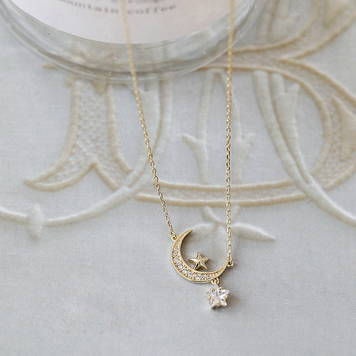 A stunning 925 sterling silver necklace with a gold-plated crescent moon and star pendant, intricately detailed with sparkling zircon stones.