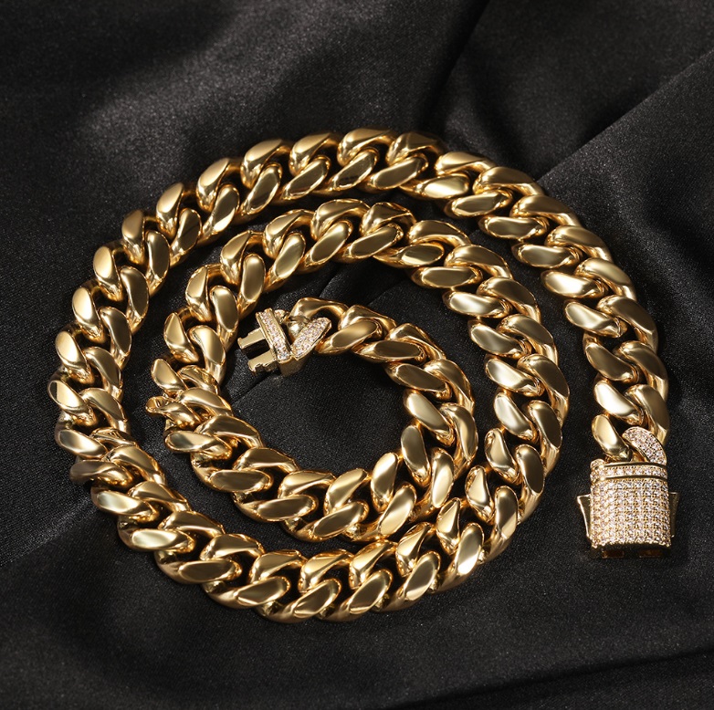 A close-up of a luxurious Hip Hop Men Gold Necklace, featuring a thick Cuban link chain with a sparkling diamond-studded clasp, showcasing premium PVD gold plating.