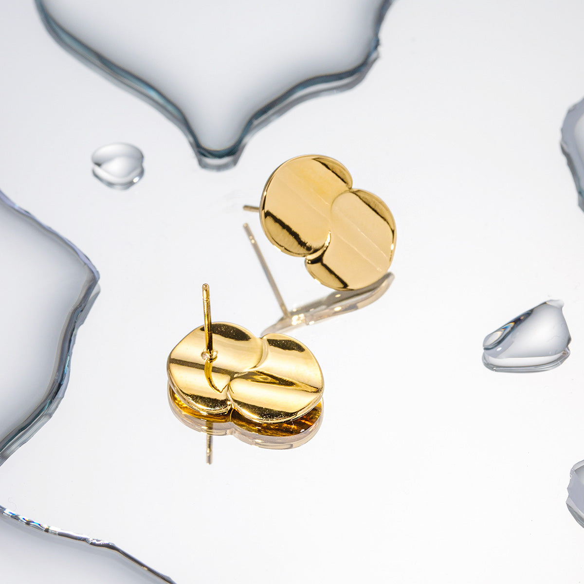 A pair of stylish stainless steel stud earrings featuring a polished gold-plated double-circle design, presented on a clean, light background.