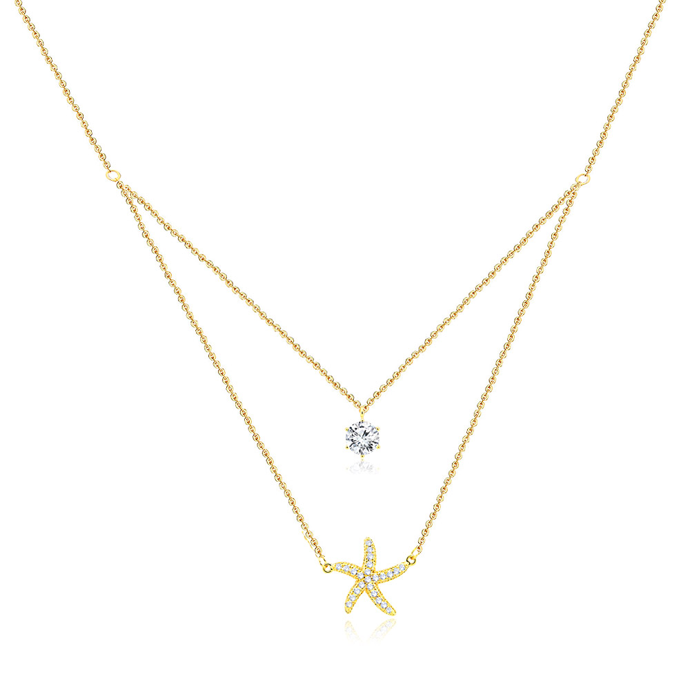 Elegant gold double-layered necklace featuring a sparkling cubic zirconia solitaire and a detailed starfish pendant, perfect for an ocean-themed look.