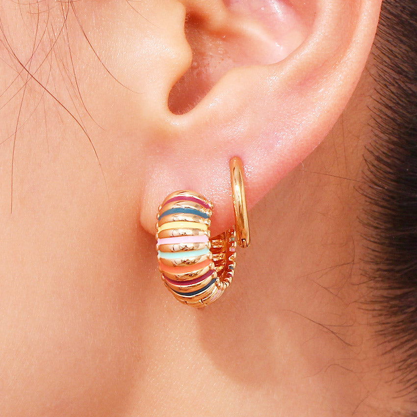 A close-up of a single 18K gold-plated stainless steel chunky hoop earring with vibrant rainbow-colored enamel stripes, on a white background.