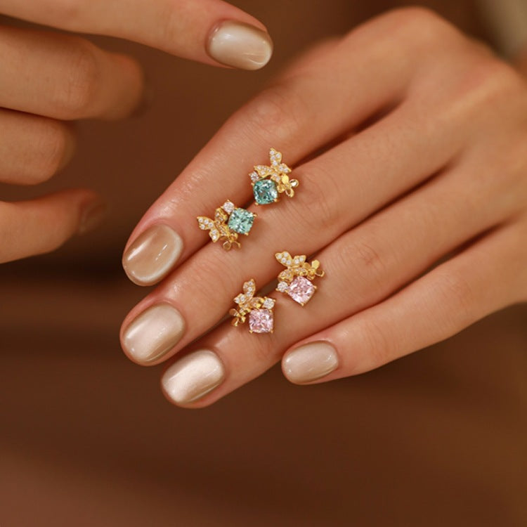 A set of five 18K gold-plated 925 sterling silver butterfly stud earrings, showcasing both the pink and blue cubic zirconia options.