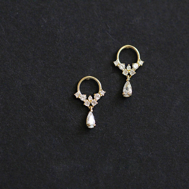 A pair of 925 silver gold-plated teardrop hoop earrings featuring a floral design with sparkling clear zircon gemstones, displayed on a white surface.
