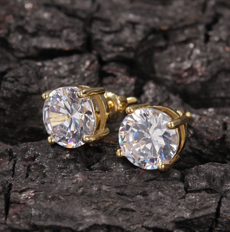 A pair of custom Round Moissanite Solarite Earrings in a brilliant gold setting, featuring large, sparkling clear gemstones against a dark background.