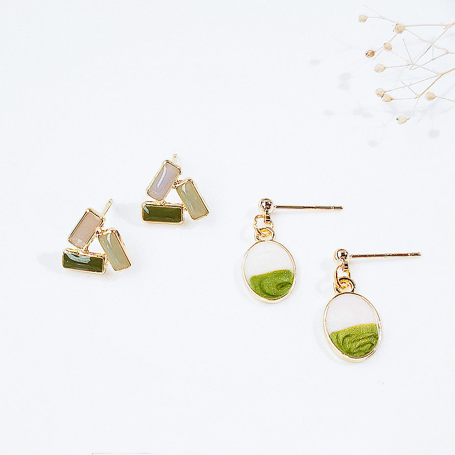 A set of gold-plated spring style stud earrings featuring fashionable enamel designs in green and neutral colors.