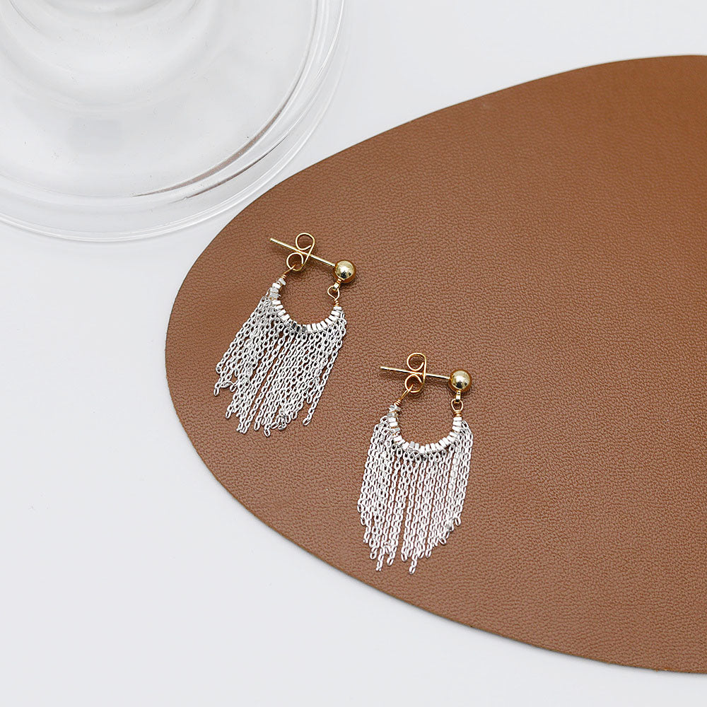 A pair of stylish silver-plated tassel drop earrings with a gold post and ball design, showcasing the delicate silver chain tassels.