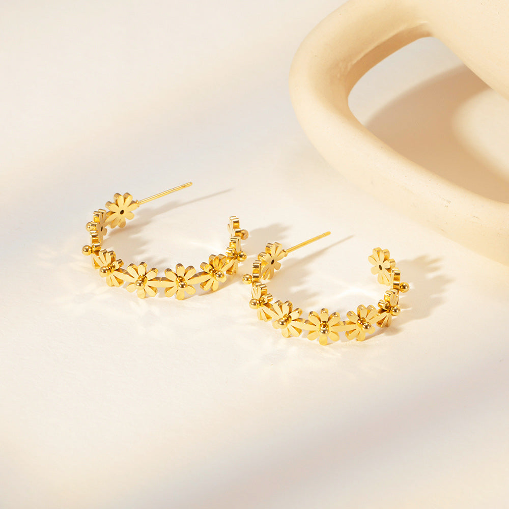 A pair of stainless steel gold-plated C-shaped stud earrings with an elegant floral design, displayed on a clean white background.